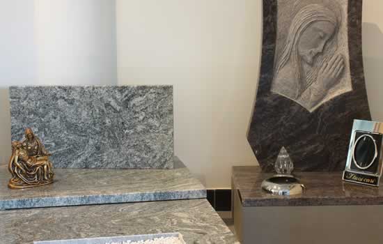 Lapidi e tombe a terra in marmo con decorazioni in altorilievo